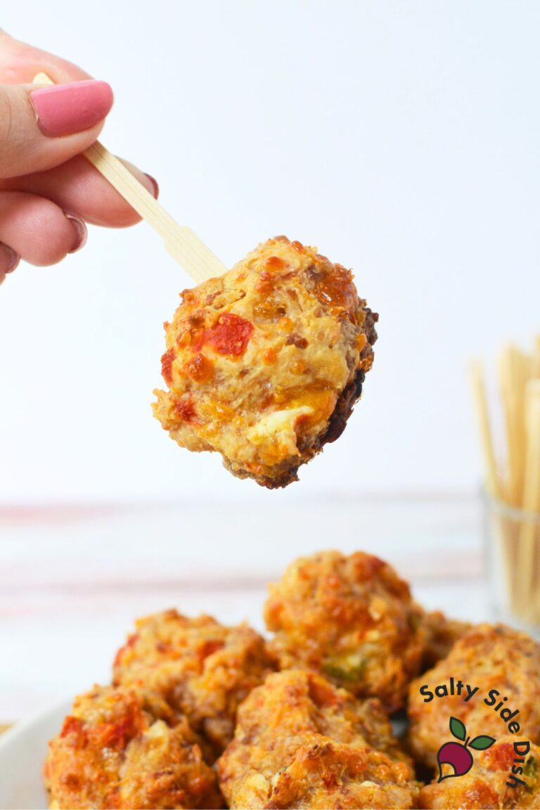 Holding a single Rotel sausage ball appetizer with a toothpick