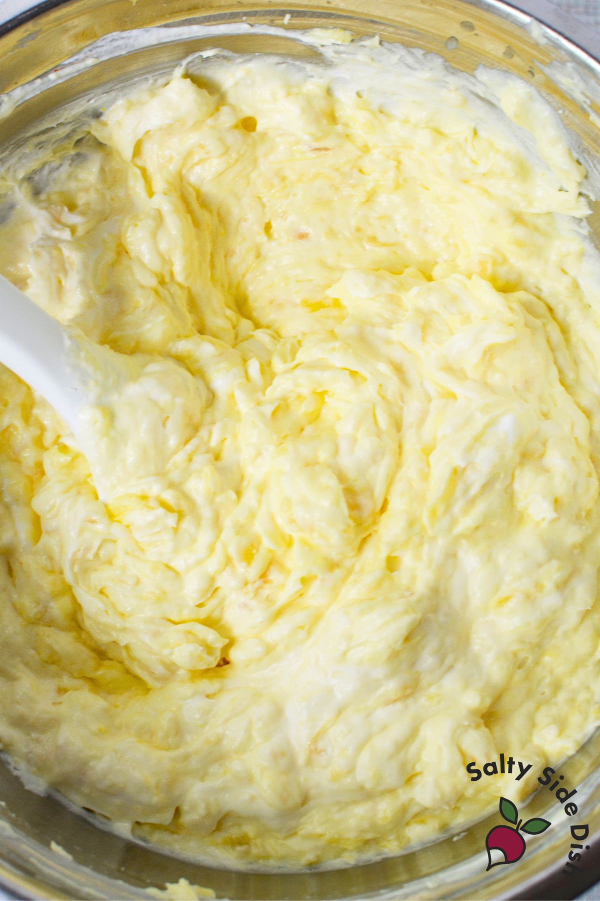 Close-up of pineapple and pudding fruit dip after mixing, showing creamy whipped texture