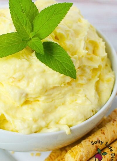 Close-up of finished pineapple dip recipe in bowl with fresh mint and vanilla sticks for dipping