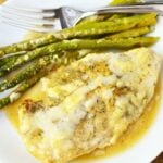 Cast iron Caesar chicken skillet dinner with asparagus served on a white plate