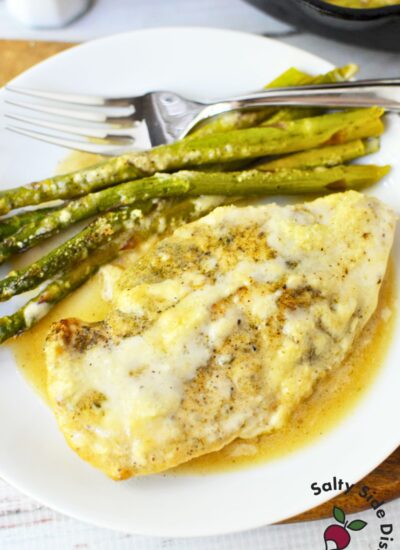 Cast iron Caesar chicken skillet dinner with asparagus served on a white plate