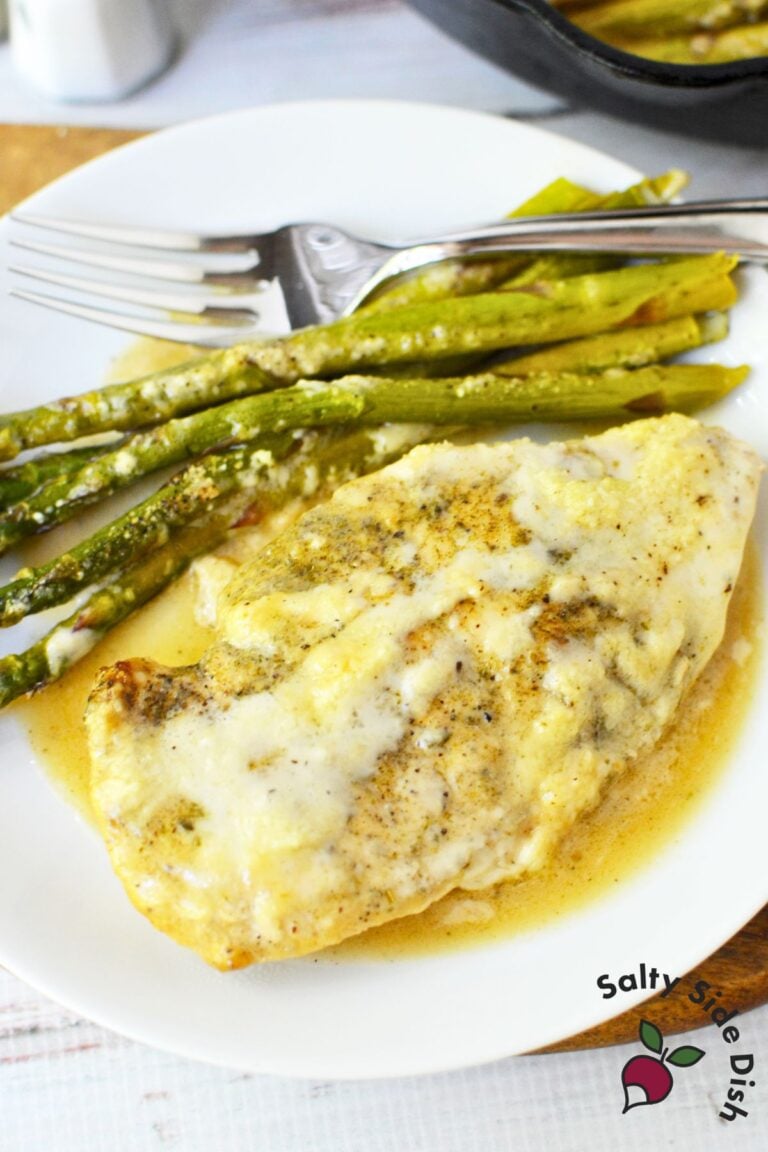 Cast iron Caesar chicken skillet dinner with asparagus served on a white plate