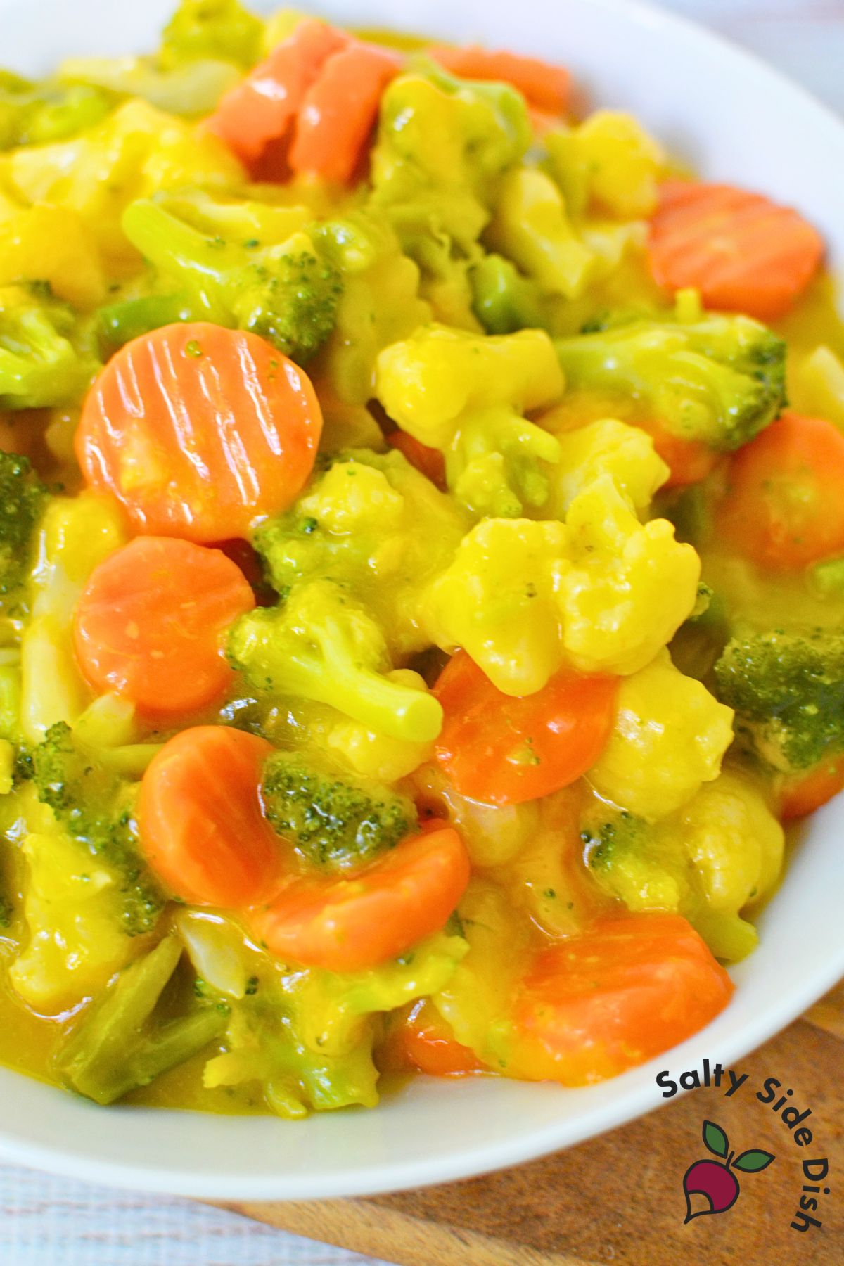 Frozen vegetables mixed with cheddar soup and broth in crock pot