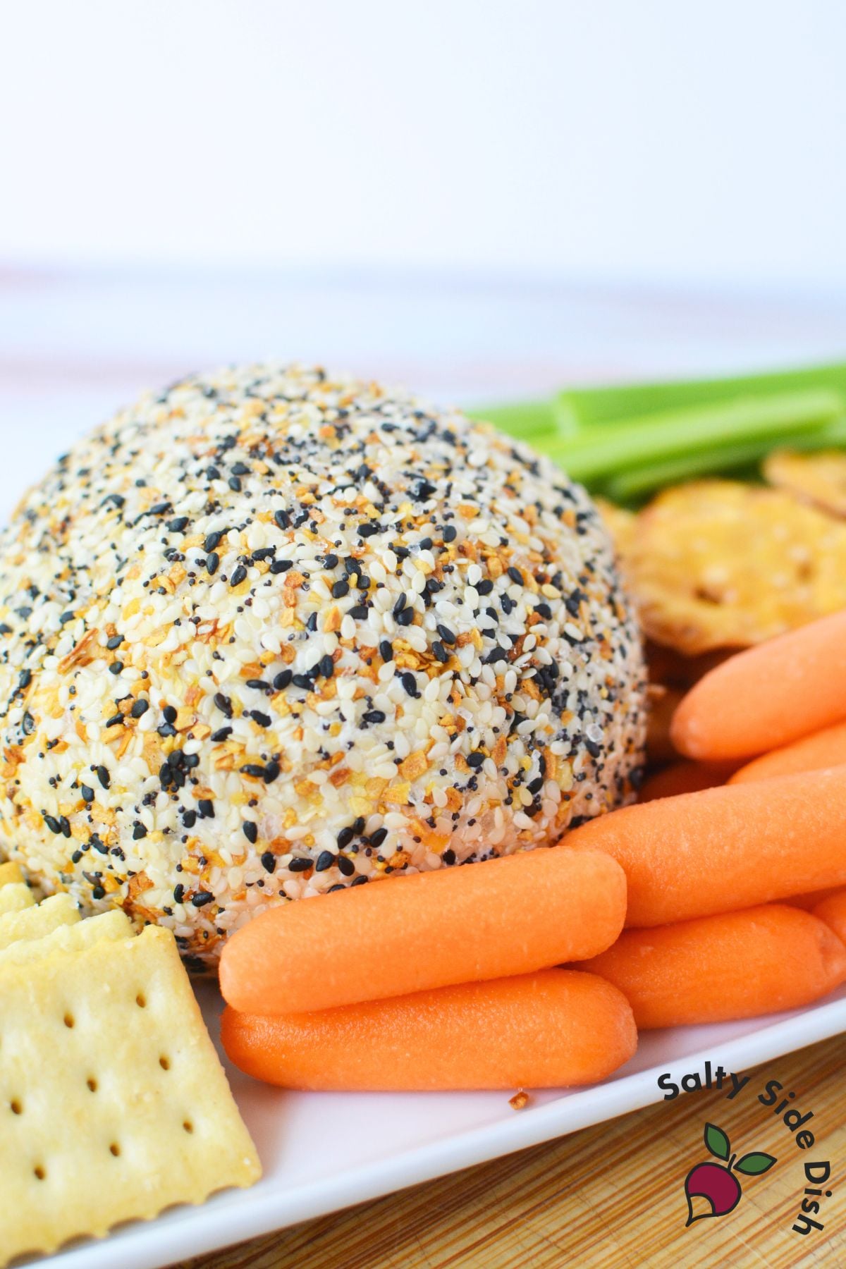 Party platter with everything bagel cheese ball, carrots, celery, pretzels, and crackers