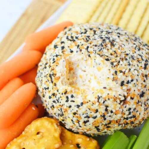 Everything bagel cheese ball appetizer with carrots, celery sticks, and crackers
