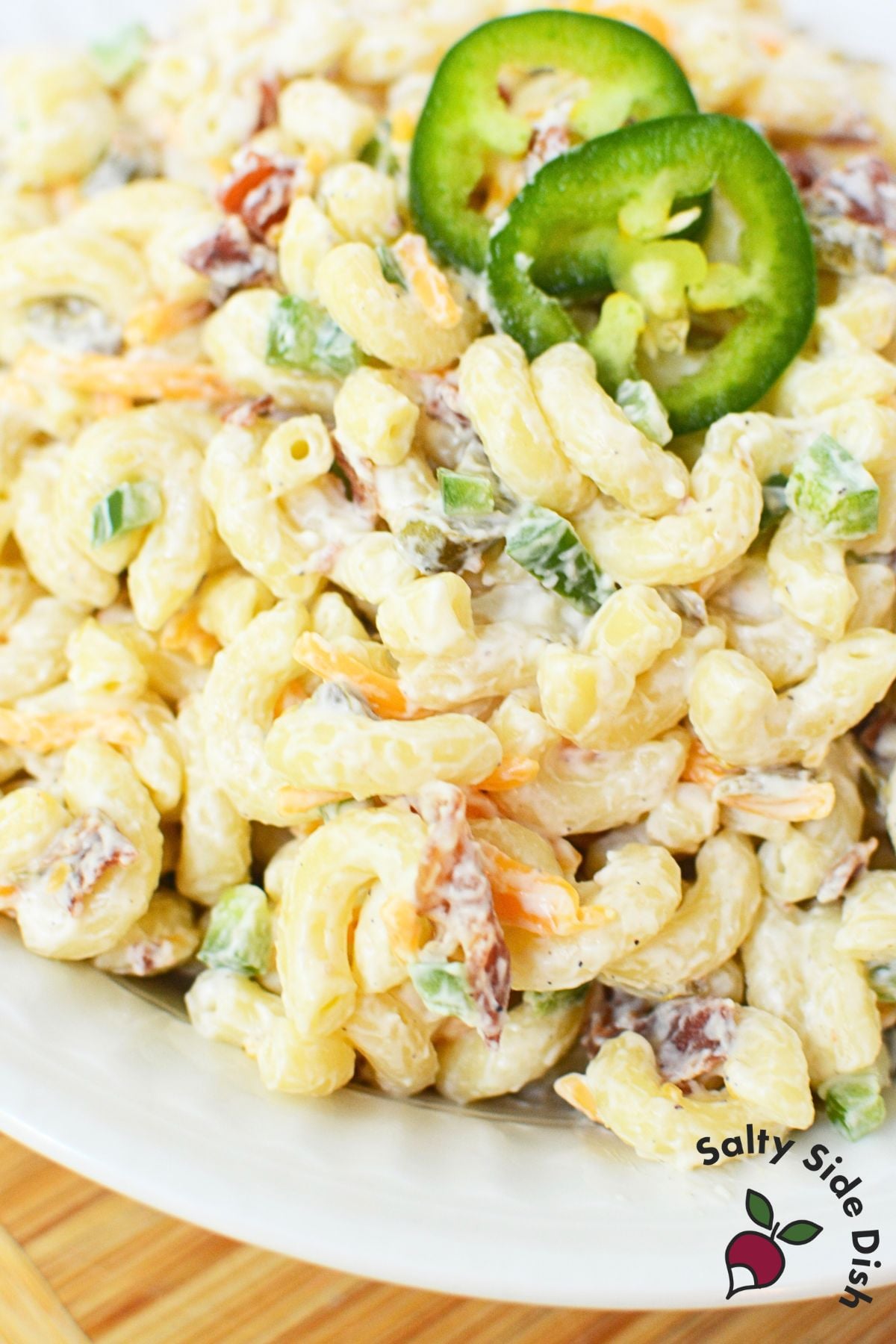 Elbow macaroni coated in cream cheese pasta salad dressing before adding bacon, cheese, and jalapenos
