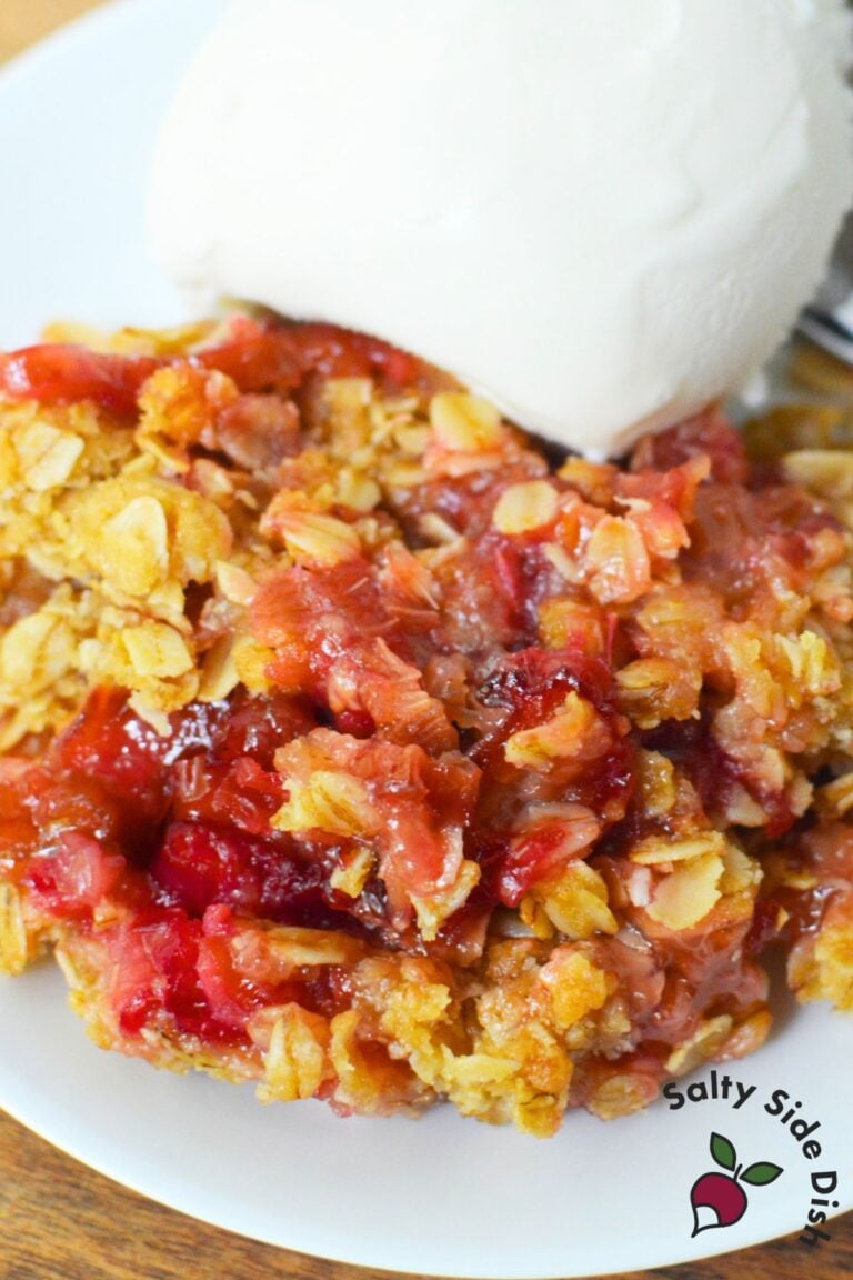 tart rhubarb crisp on a plate with vanilla ice cream.