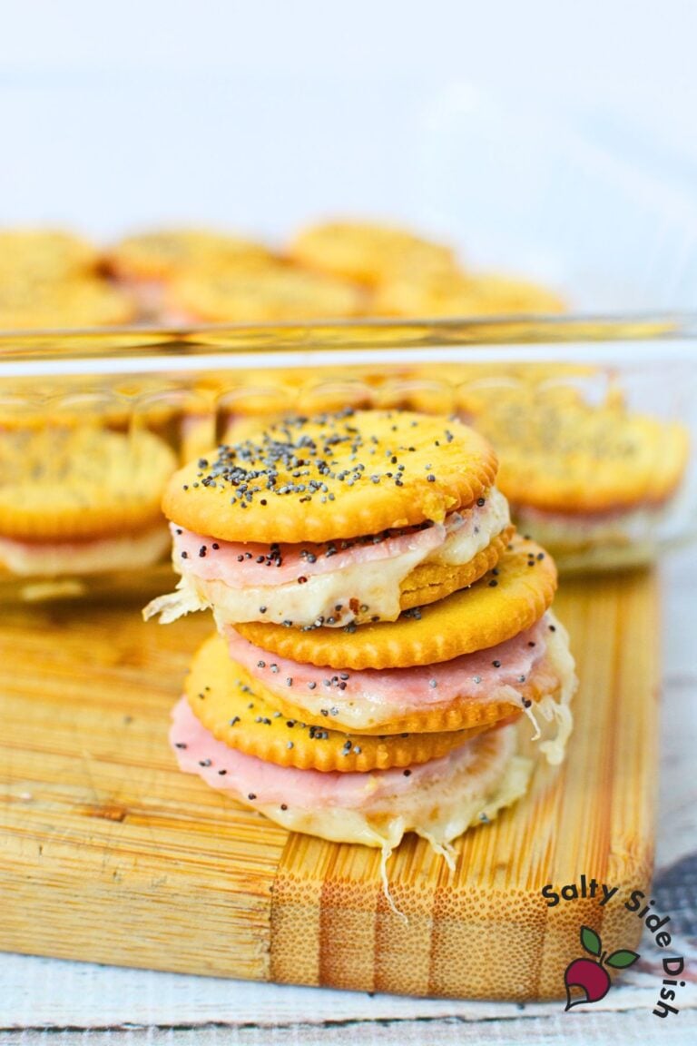 Stack of melted ham and cheese Ritz cracker sandwiches baked until golden and crisp.