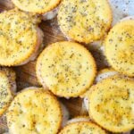 Overhead shot of baked Ritz crackers party sandwiches topped with poppy seeds.