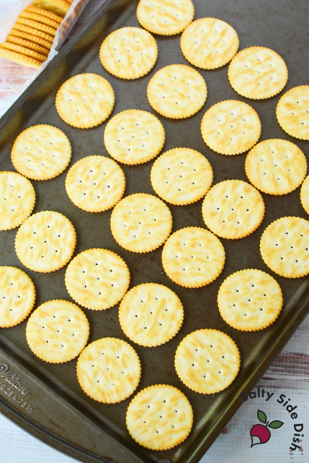 Hand pressing second Ritz cracker over melted Rolo candy to make sandwich cookie