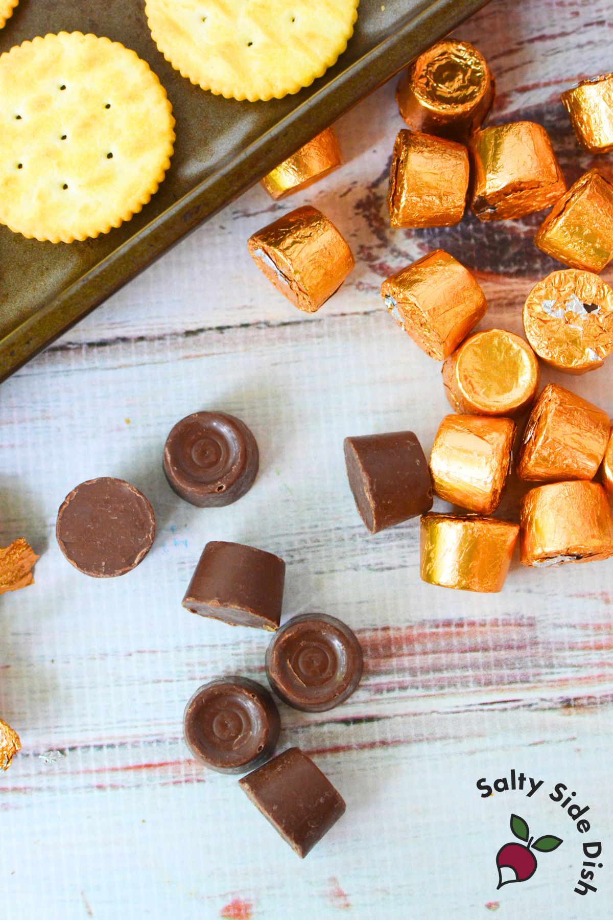 Unwrapped Rolo chocolates and Ritz crackers on baking sheet ready for assembly