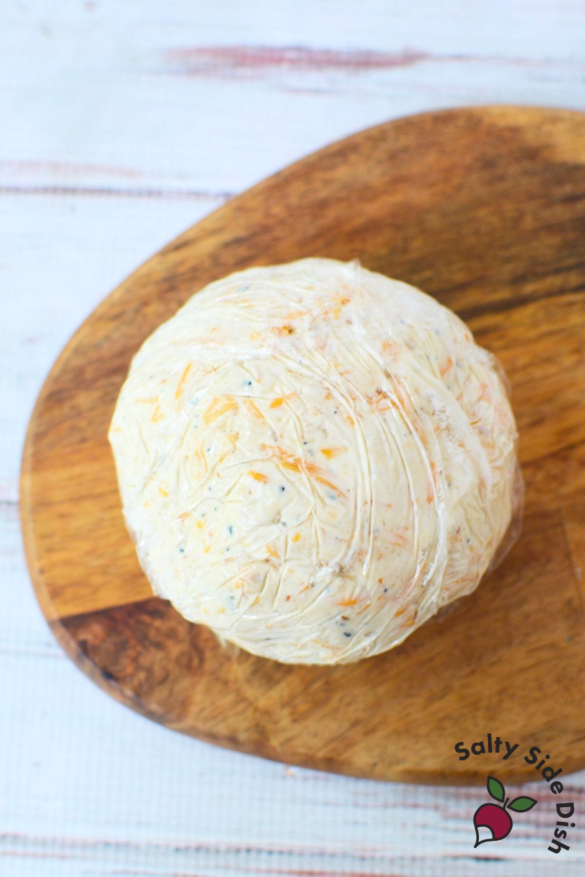 Cheese ball wrapped in plastic wrap before chilling to set