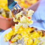forkful of sausage pasta bake with pasta, sausage, cheese, and biscuit topping