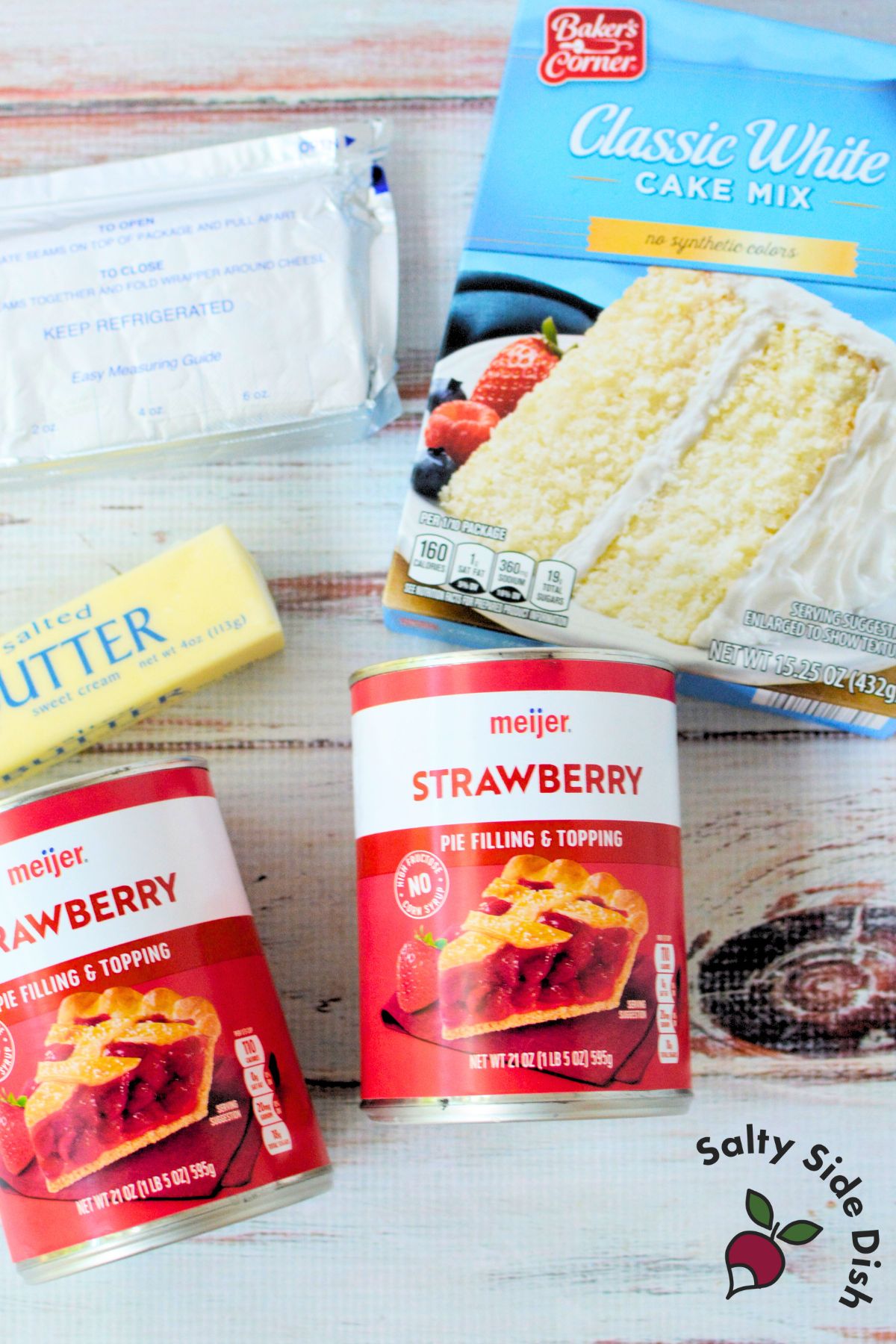 Ingredients for strawberry cheesecake dump cake including white cake mix, strawberry pie filling, butter, and cream cheese.