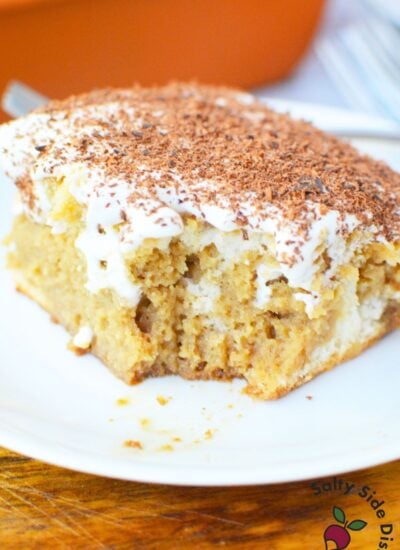 Close up of tiramisu poke cake with creamy mascarpone topping and chocolate shavings.