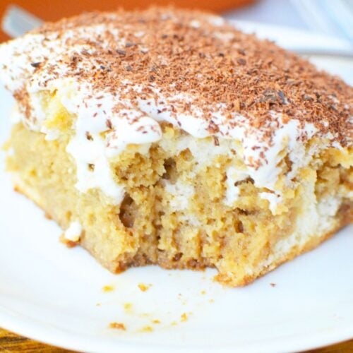 Close up of tiramisu poke cake with creamy mascarpone topping and chocolate shavings.