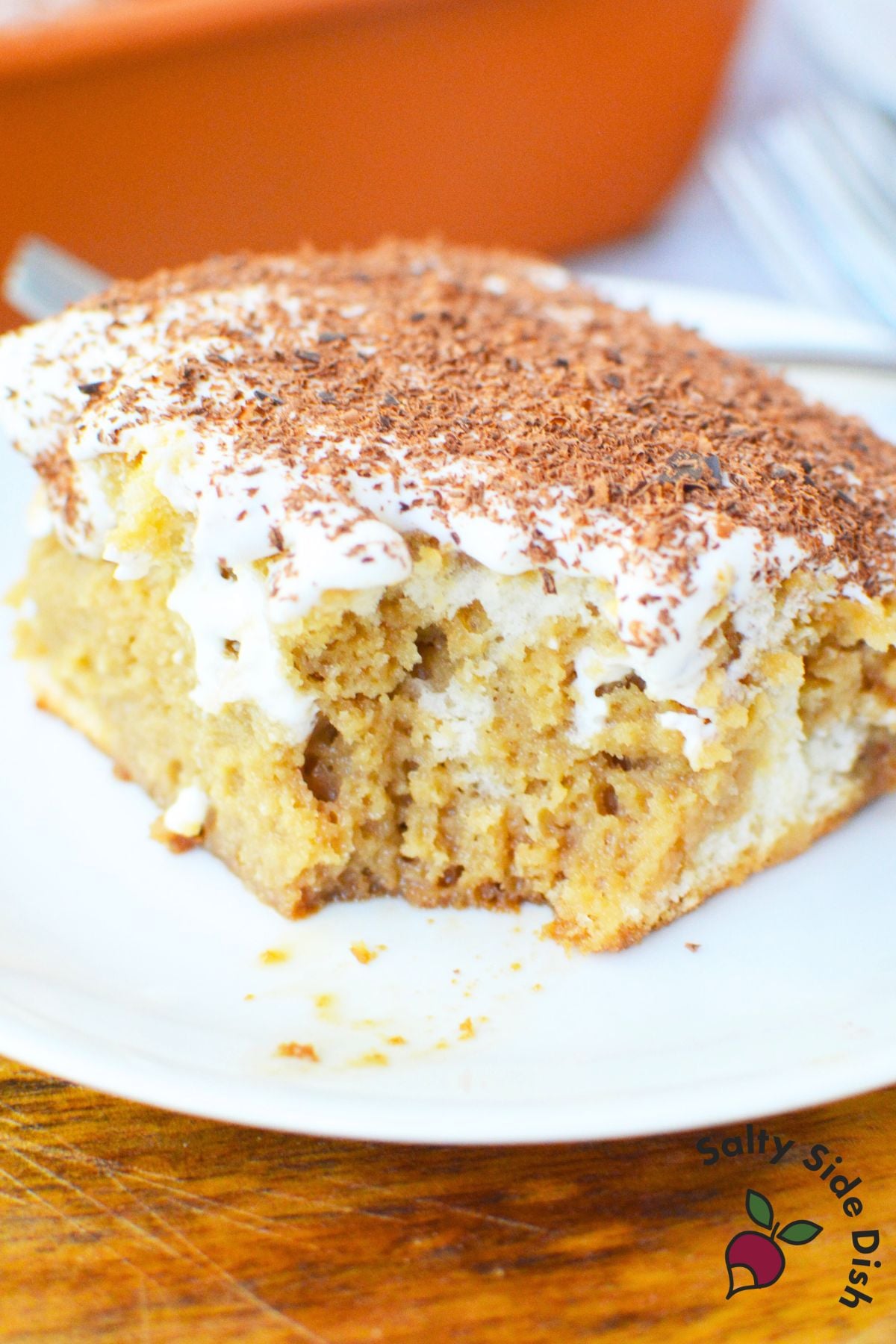 Close up of tiramisu poke cake with creamy mascarpone topping and chocolate shavings.