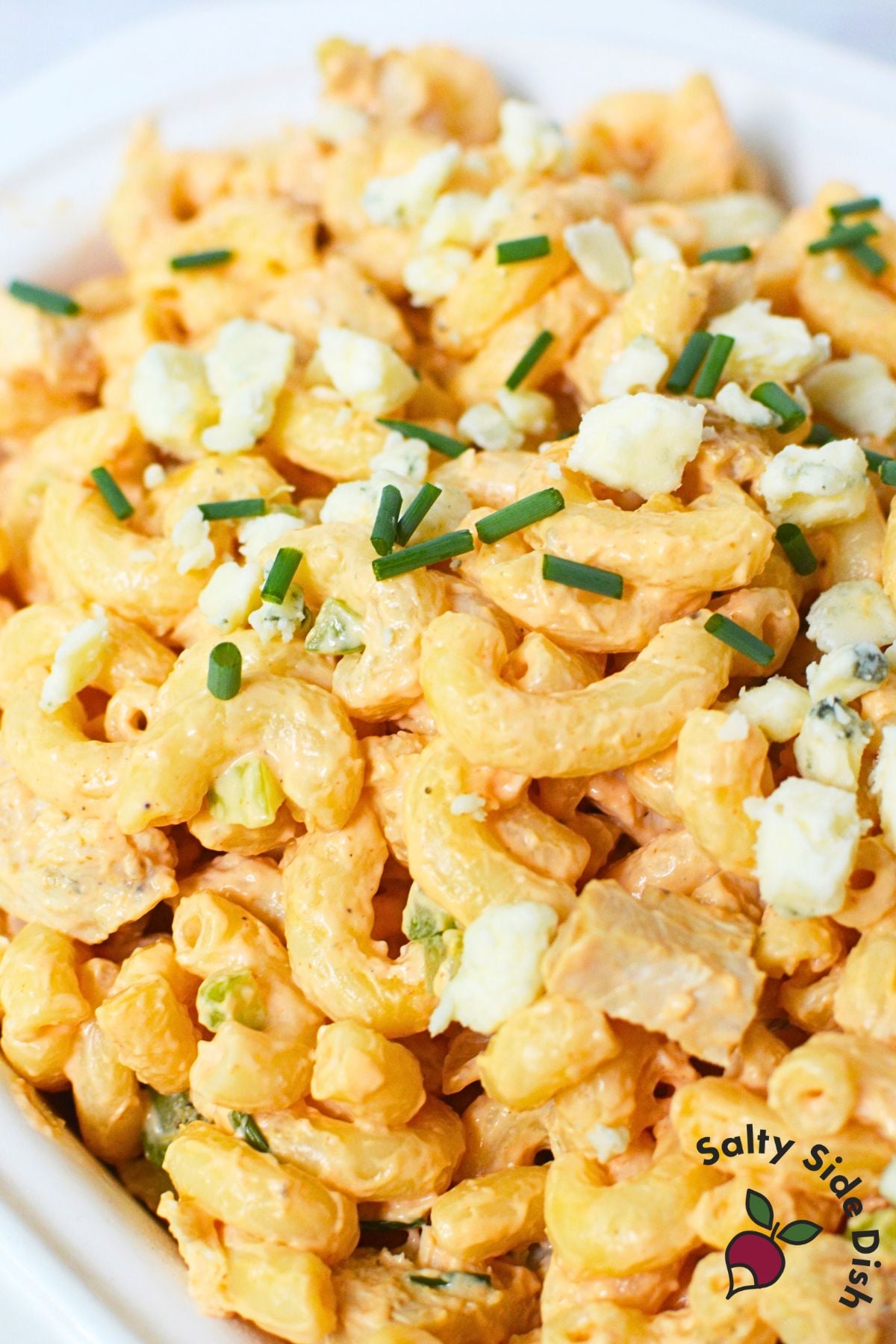 Overhead view of buffalo chicken pasta salad with chives and blue cheese