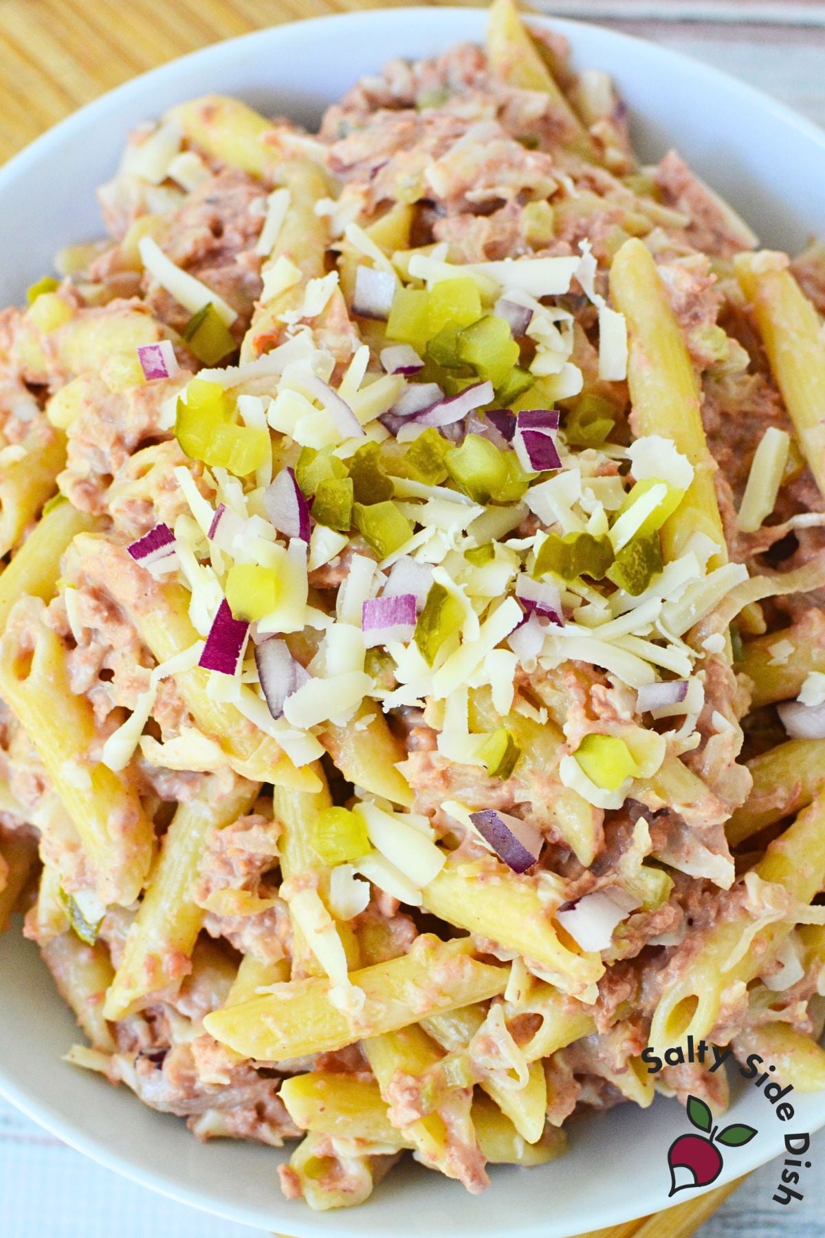 Creamy Reuben pasta salad with penne, corned beef, Swiss cheese, pickles, and onions served chilled.
