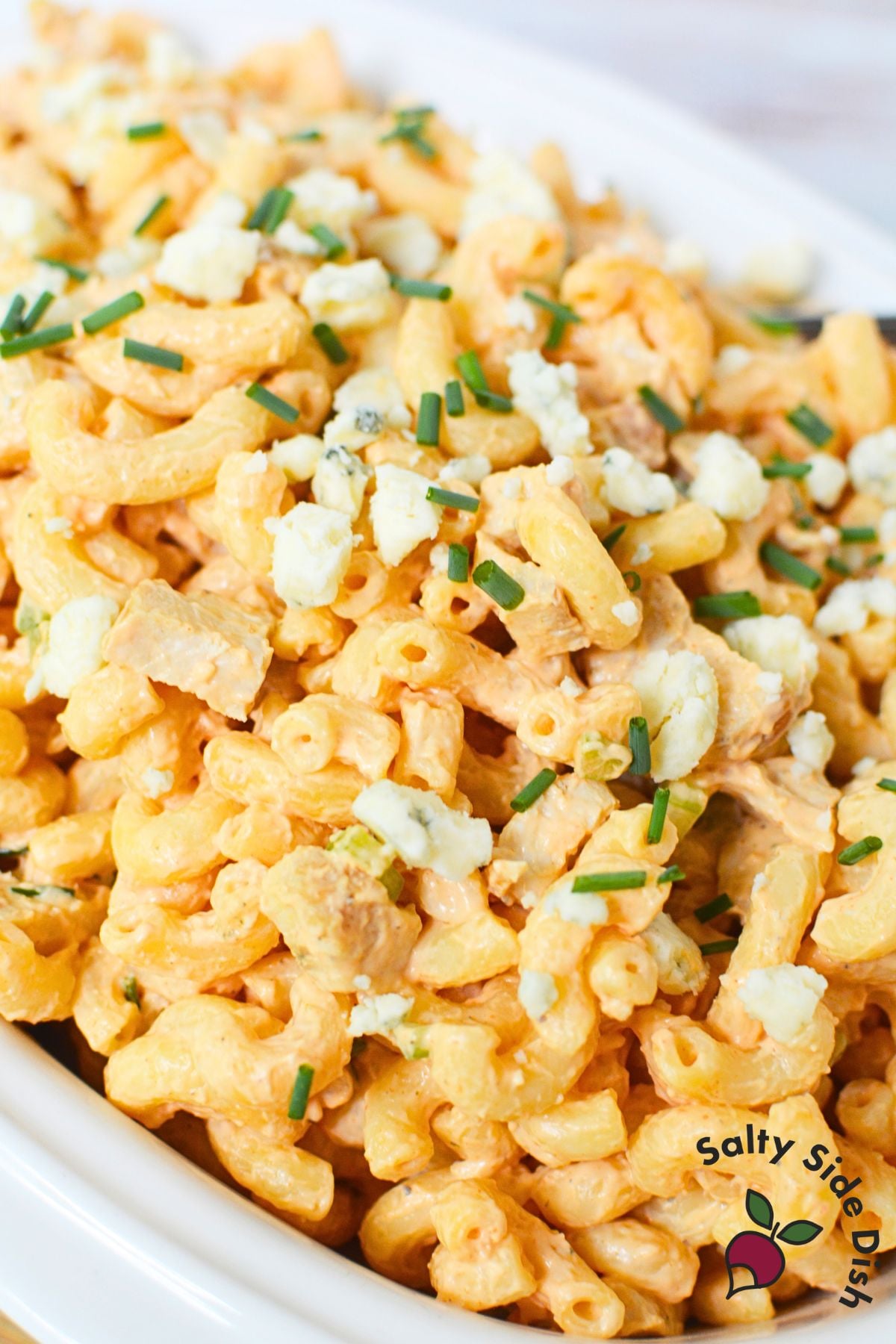Close-up of creamy buffalo chicken pasta salad with pasta, chicken, and blue cheese