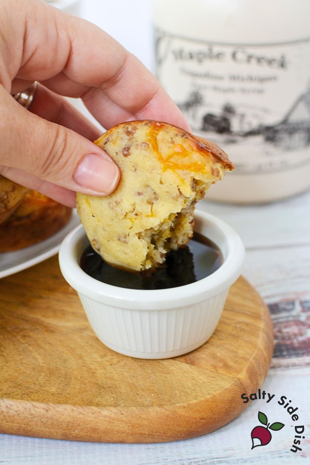 Dipping a McGriddle muffin into a small bowl of maple syrup