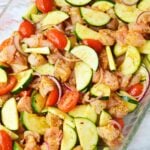 Mediterranean zucchini chicken bake ingredients arranged in a casserole dish before baking.
