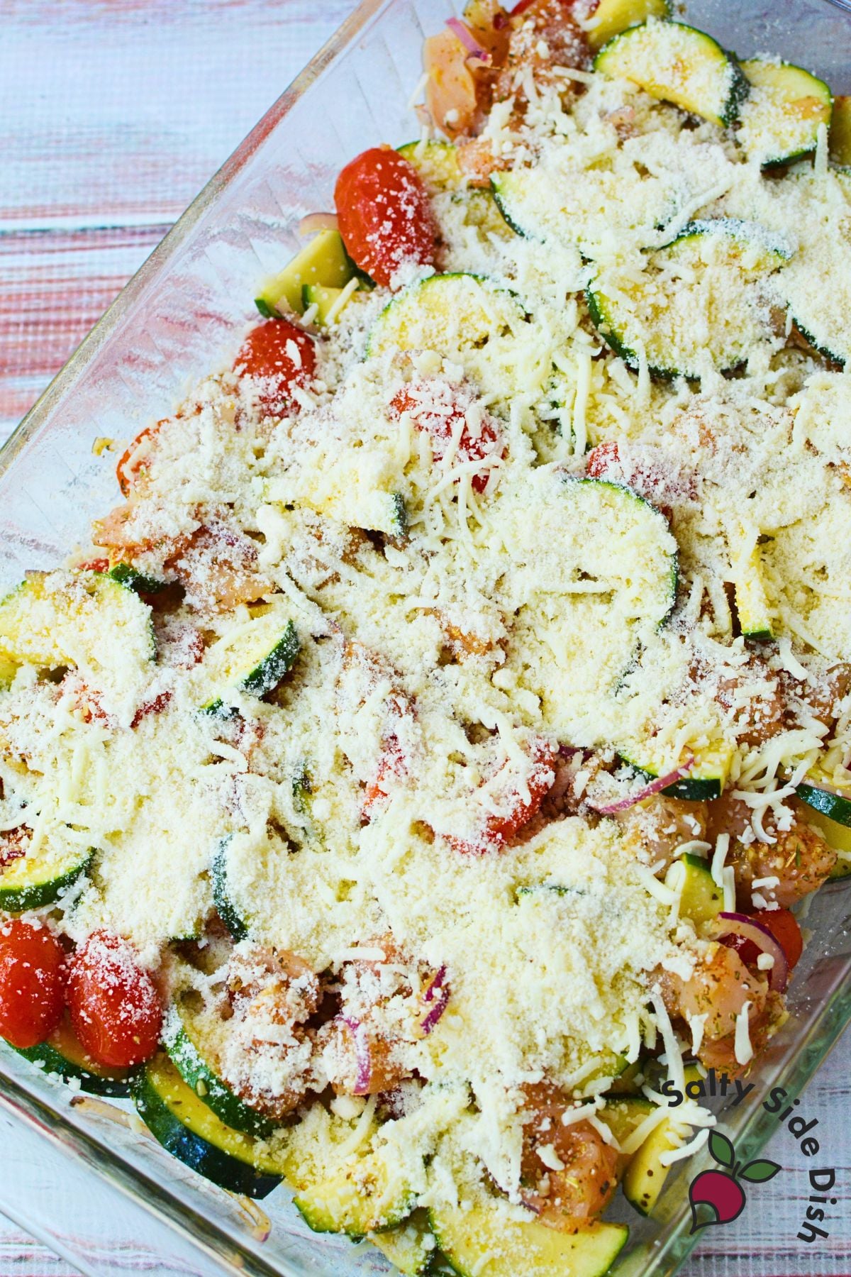 Mediterranean chicken bake topped with mozzarella and Parmesan cheese before going in the oven.