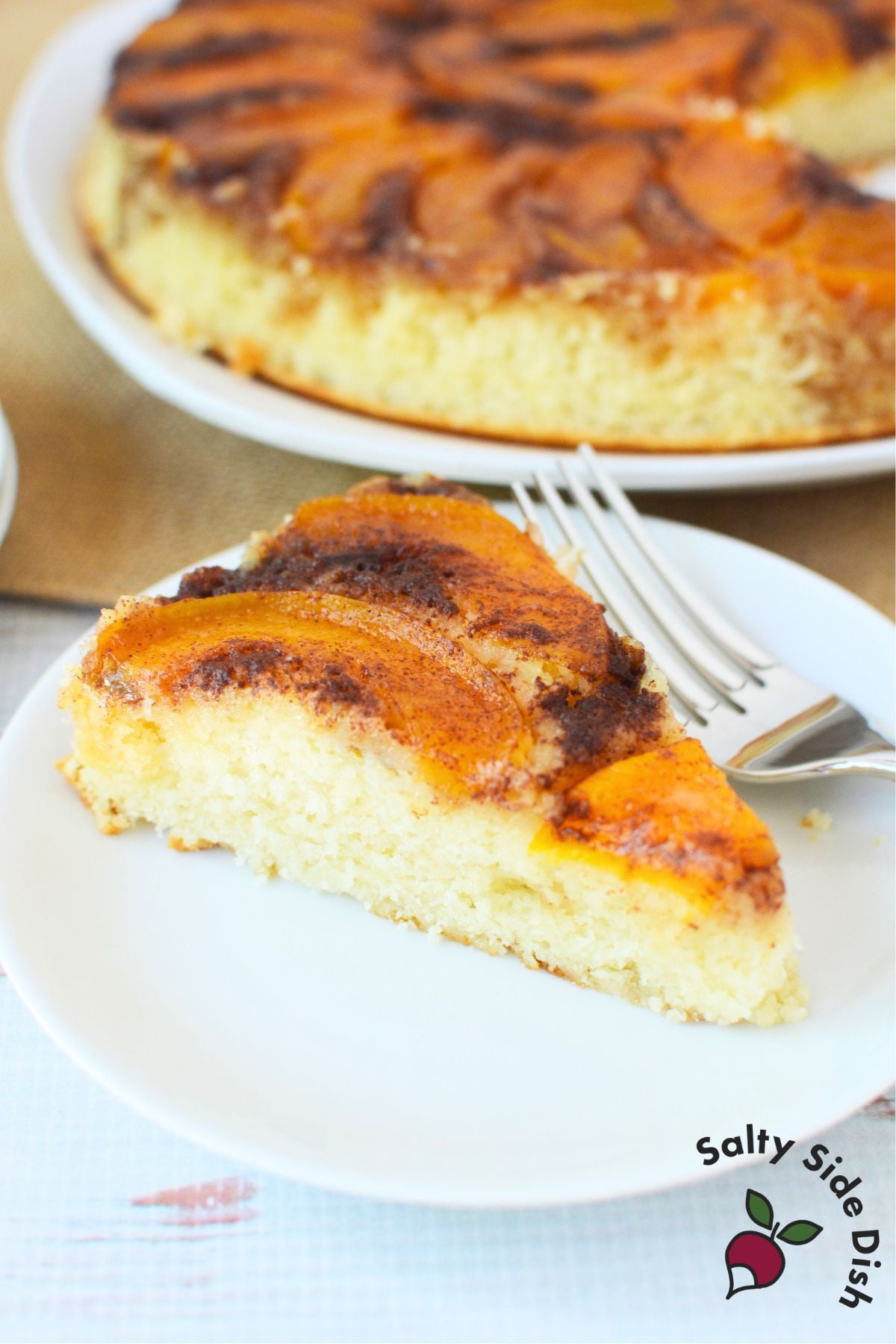 Serving peach upside down cake slice with fork