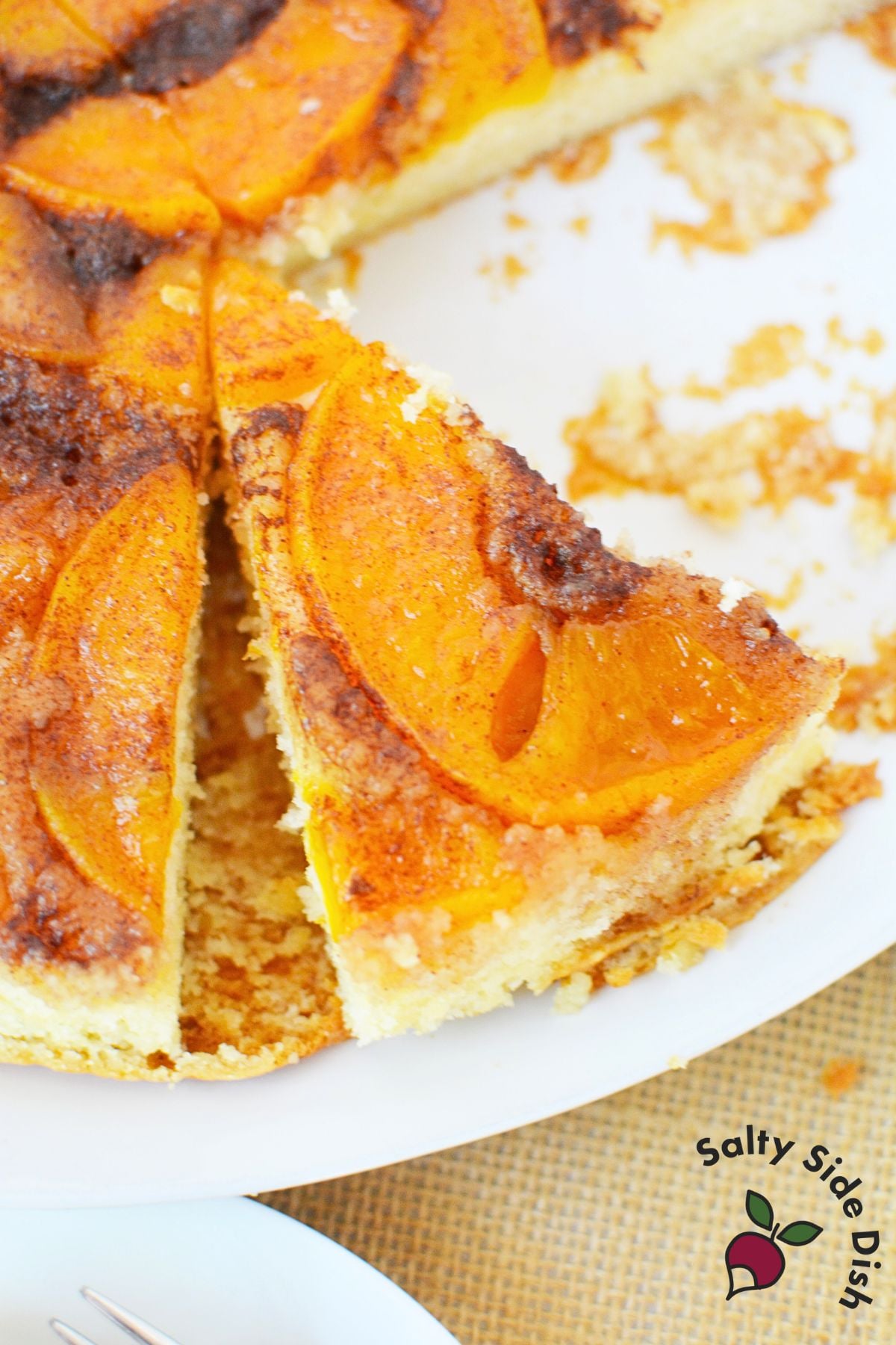 Slice of peach upside down cake showing caramelized peaches on top