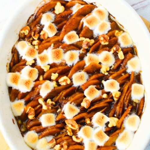 Classic scalloped sweet potatoes topped with golden marshmallows and nuts