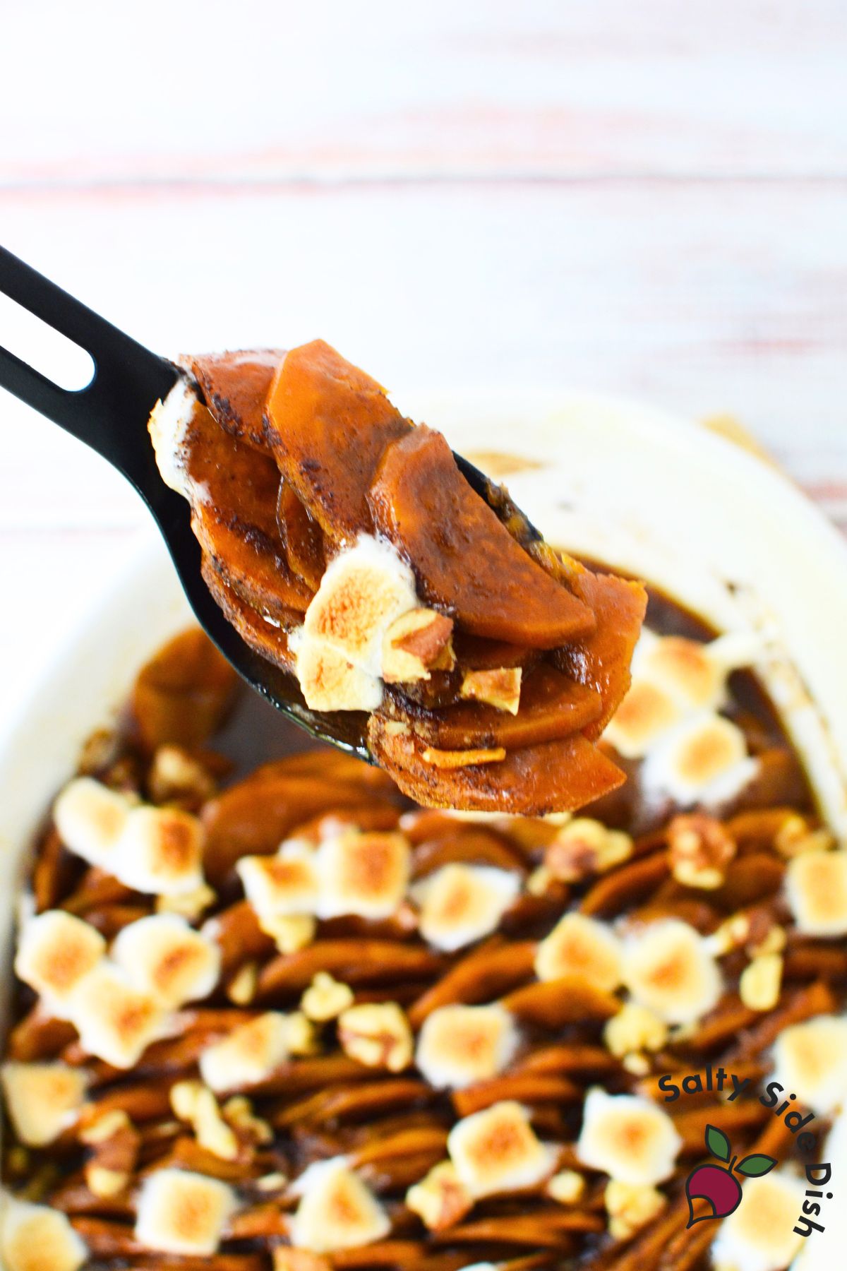 Spoonful of scalloped sweet potatoes with marshmallows on top