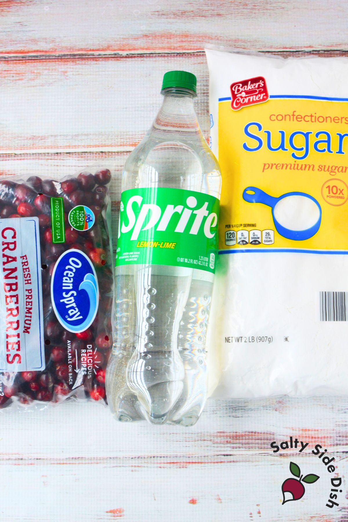 Ingredients for sugared cranberries recipe with fresh cranberries, lemon lime soda, and powdered sugar.