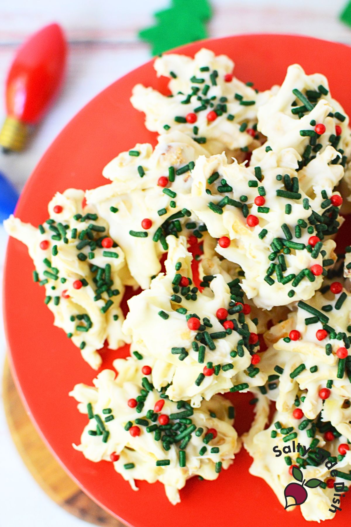 Pile of Christmas haystack cookies with red and green sprinkles on festive platter