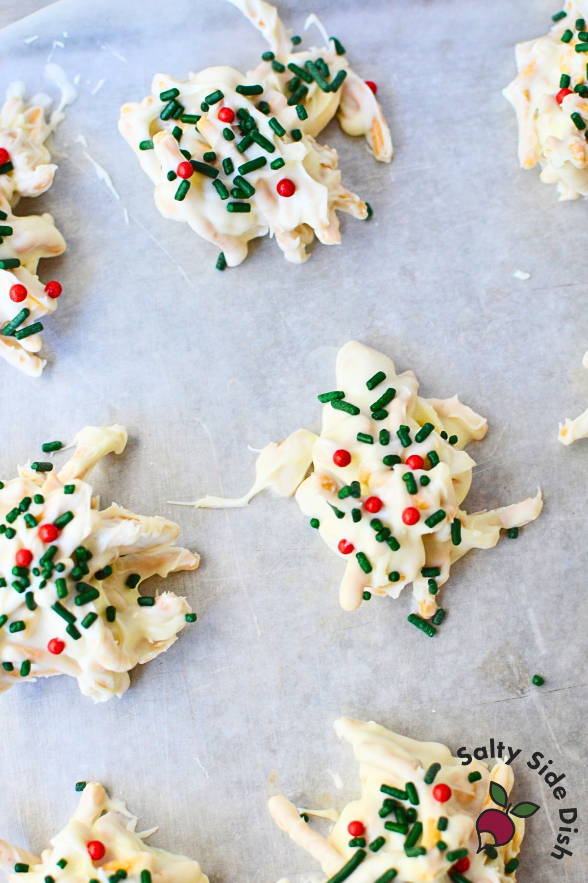 Single white chocolate haystack cookie with chow mein noodles and peanuts on wax paper