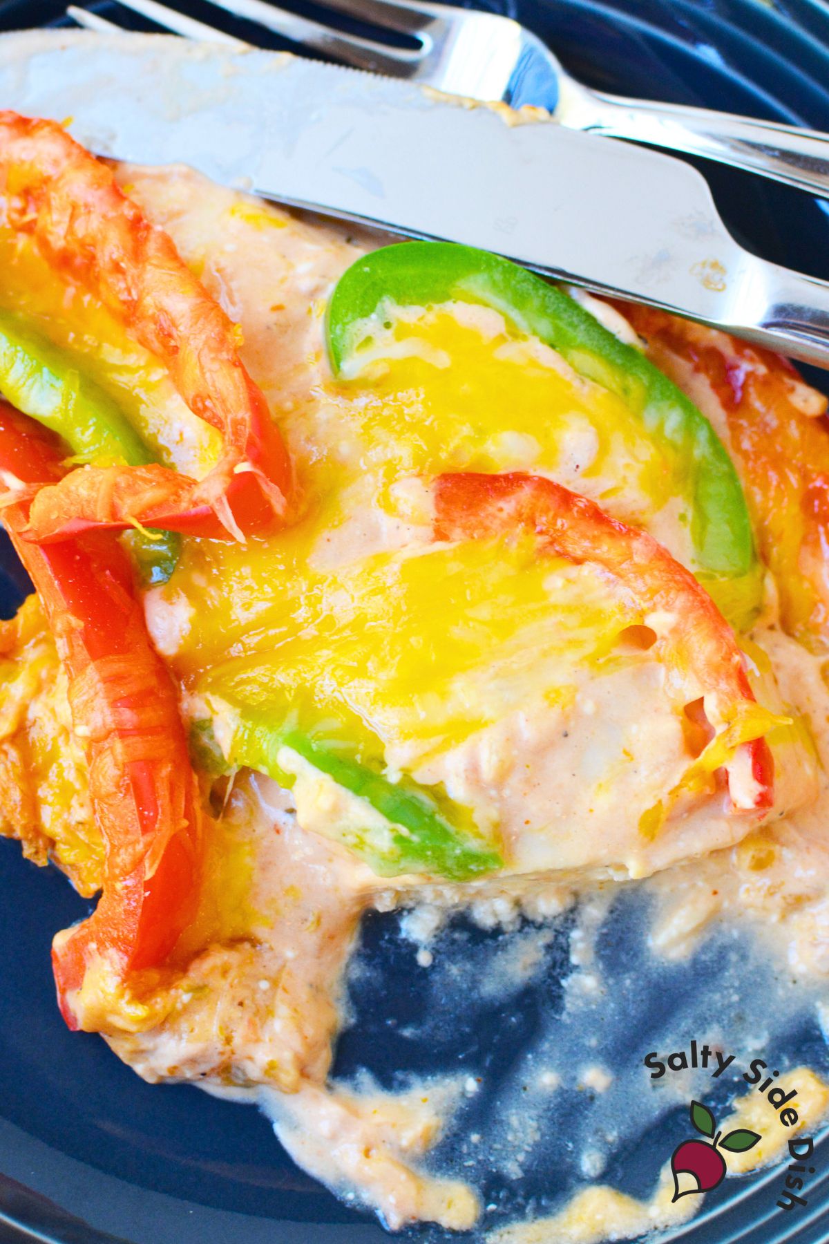 Serving of creamy chicken fajita bake on a plate with colorful peppers and melted cheese