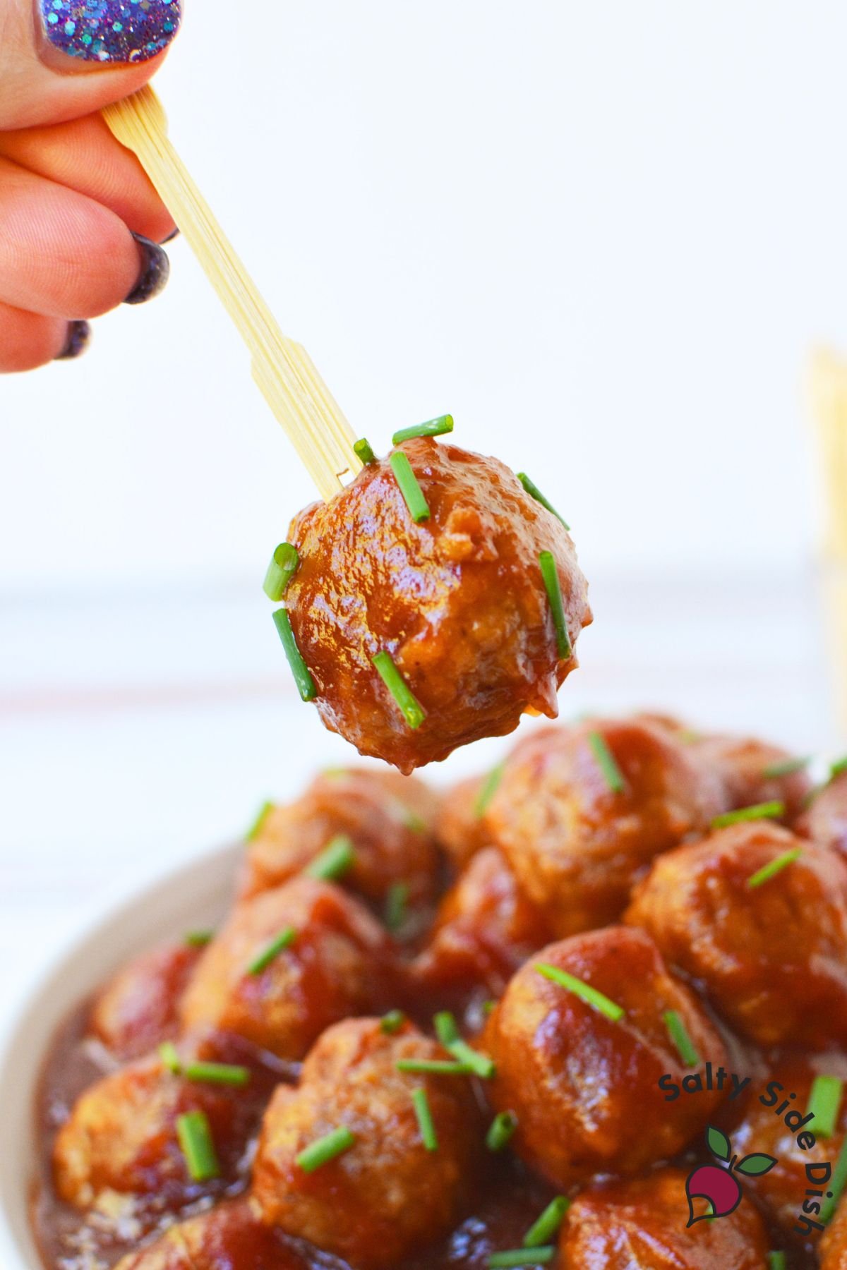 cranberry chili meatball appetizer on a toothpick ready to serve