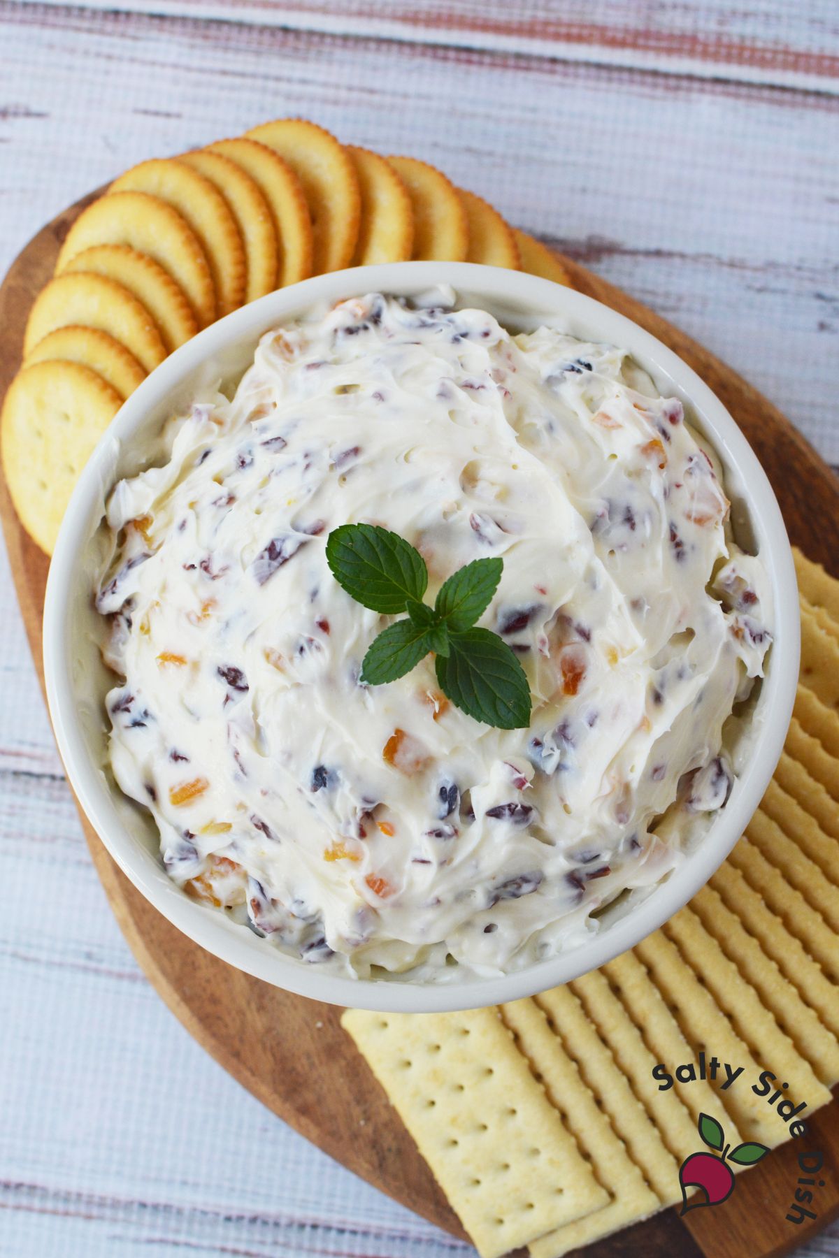 Bowl of cranberry orange and cream cheese dip served with Ritz and Town House crackers topped with fresh mint
