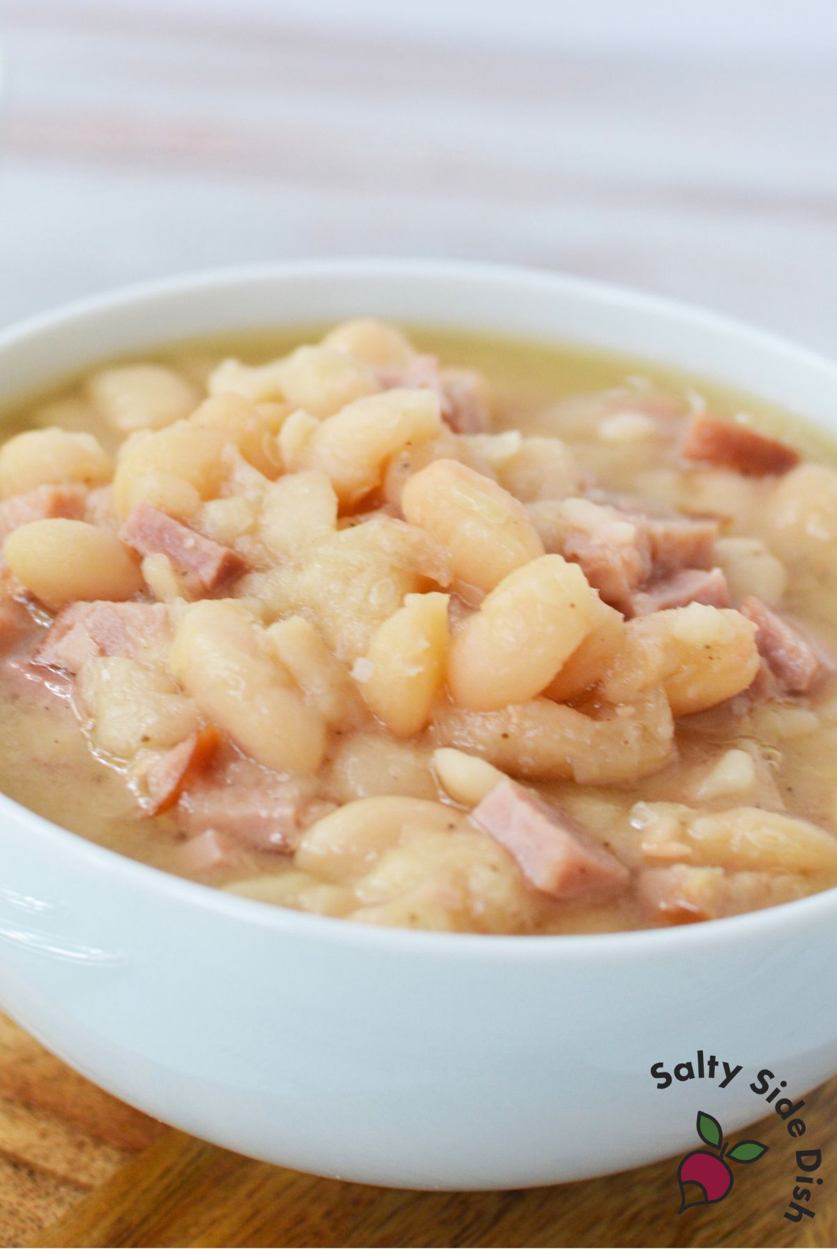 Bowl filled with slow cooked ham and beans in thick broth