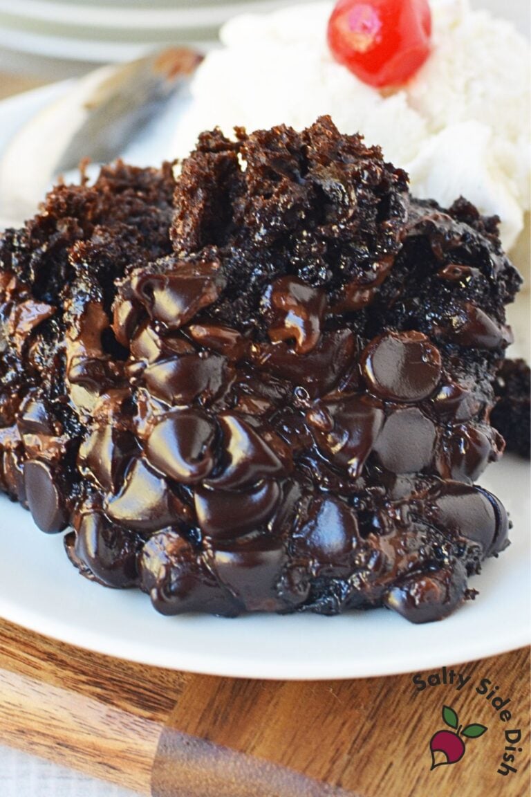 Close up of crockpot lava cake with gooey melted chocolate chips served with vanilla ice cream and cherry.