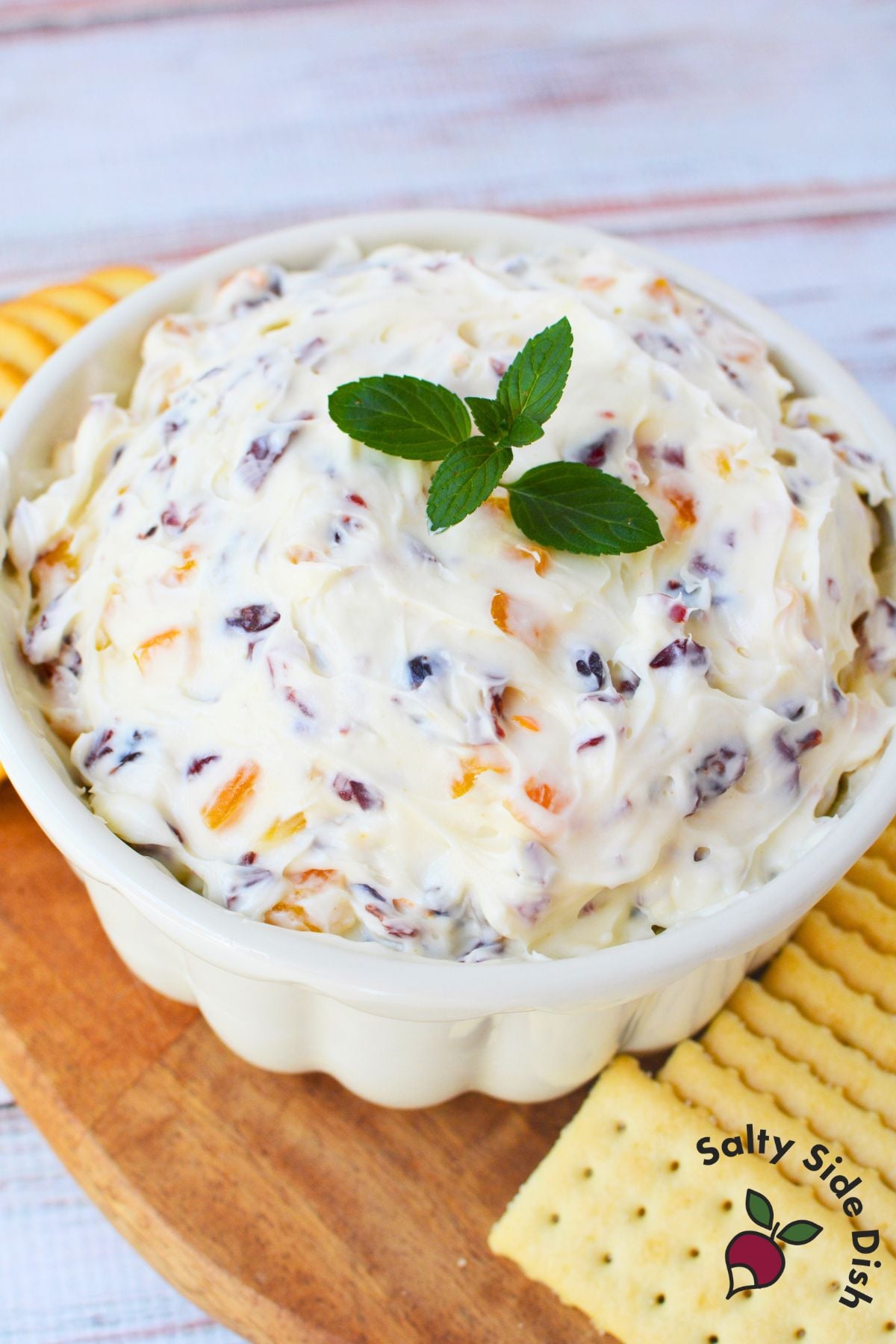 Easy holiday cranberry orange cream cheese dip served with crackers on a wooden platter