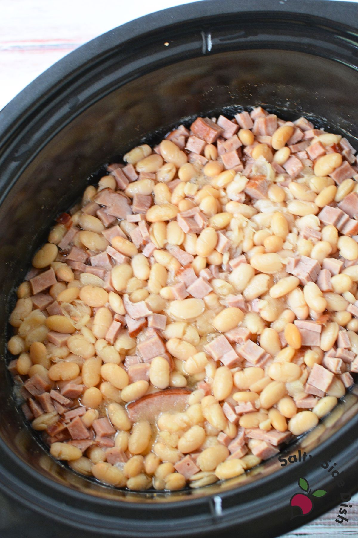 Ham and beans simmering together in a slow cooker
