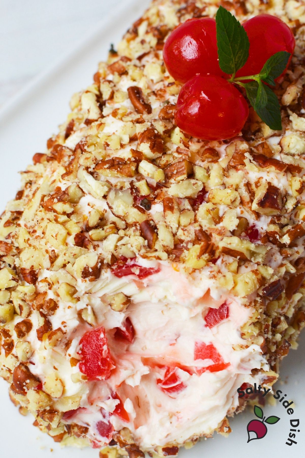 Cherry cream cheese log with pecans and maraschino cherry pieces inside, perfect for a sweet holiday appetizer