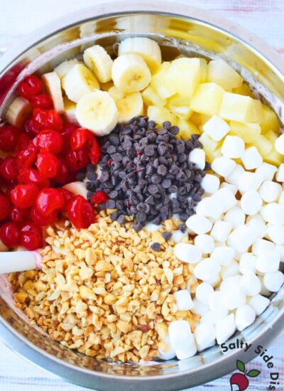 fresh bananas pineapple cherries mini marshmallows peanuts and chocolate chips in a bowl for banana split fluff salad