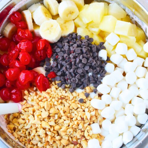 fresh bananas pineapple cherries mini marshmallows peanuts and chocolate chips in a bowl for banana split fluff salad