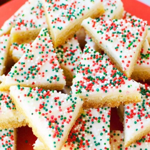 Close up of frosted sugar cookie bars decorated with red, green, and white nonpareil sprinkles