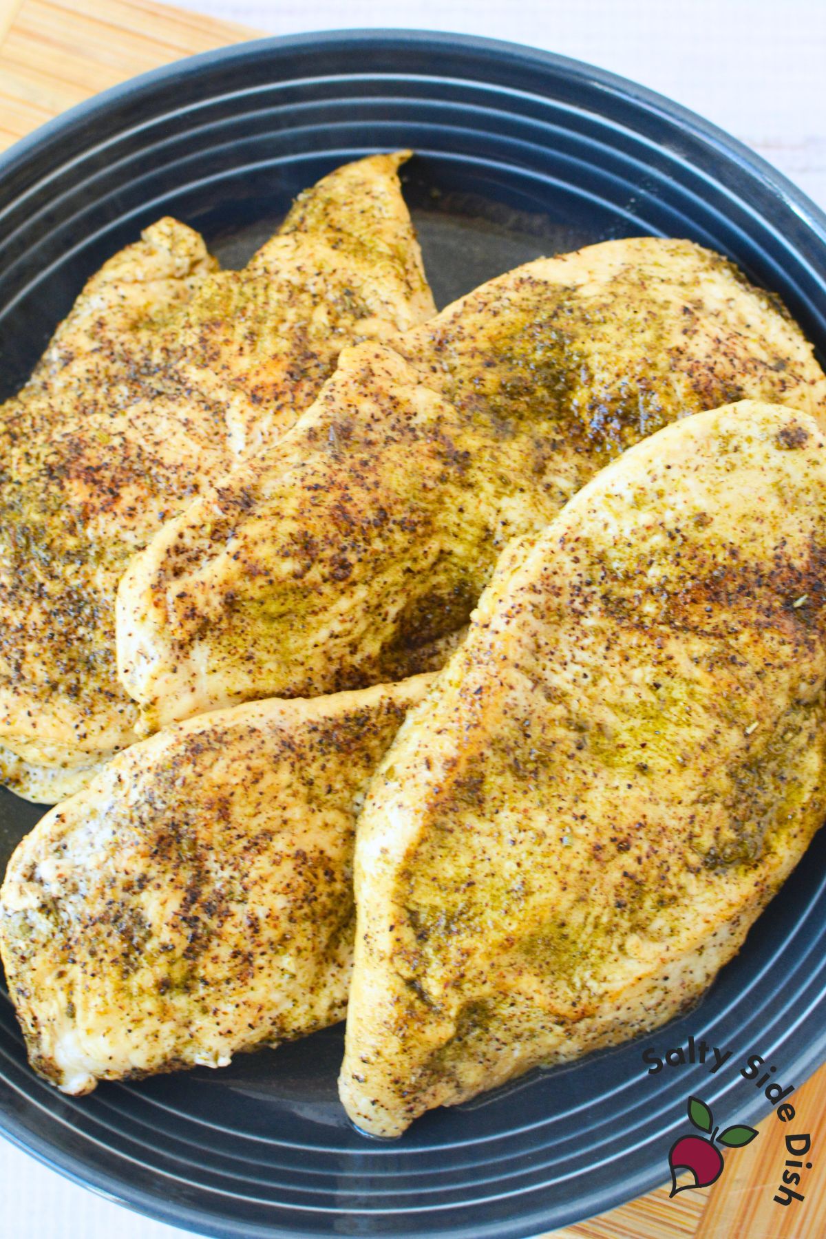Perfectly cooked chicken breasts with seasoning resting in a skillet, showing even browning and moisture.