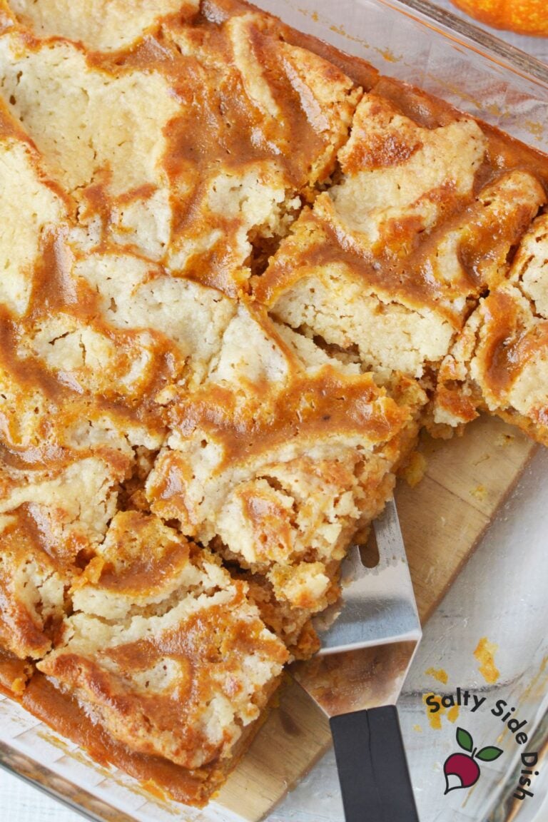 lice of pumpkin pie cake with layers of pumpkin filling and buttery crumble on white plate