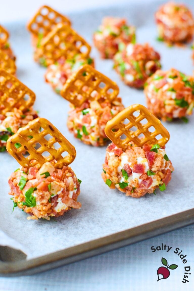 Mini cheeseball bites on a white serving platter with pretzels inserted, showing a simple cream cheese, bacon, and ranch appetizer recipe.