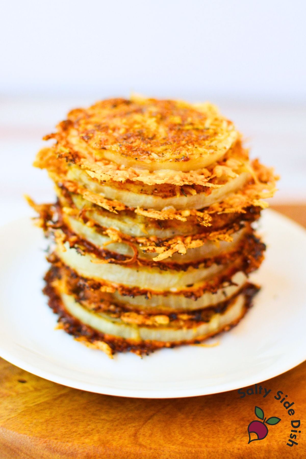 Stacked crispy oven baked onion rings from TikTok recipe showing golden cheesy layers