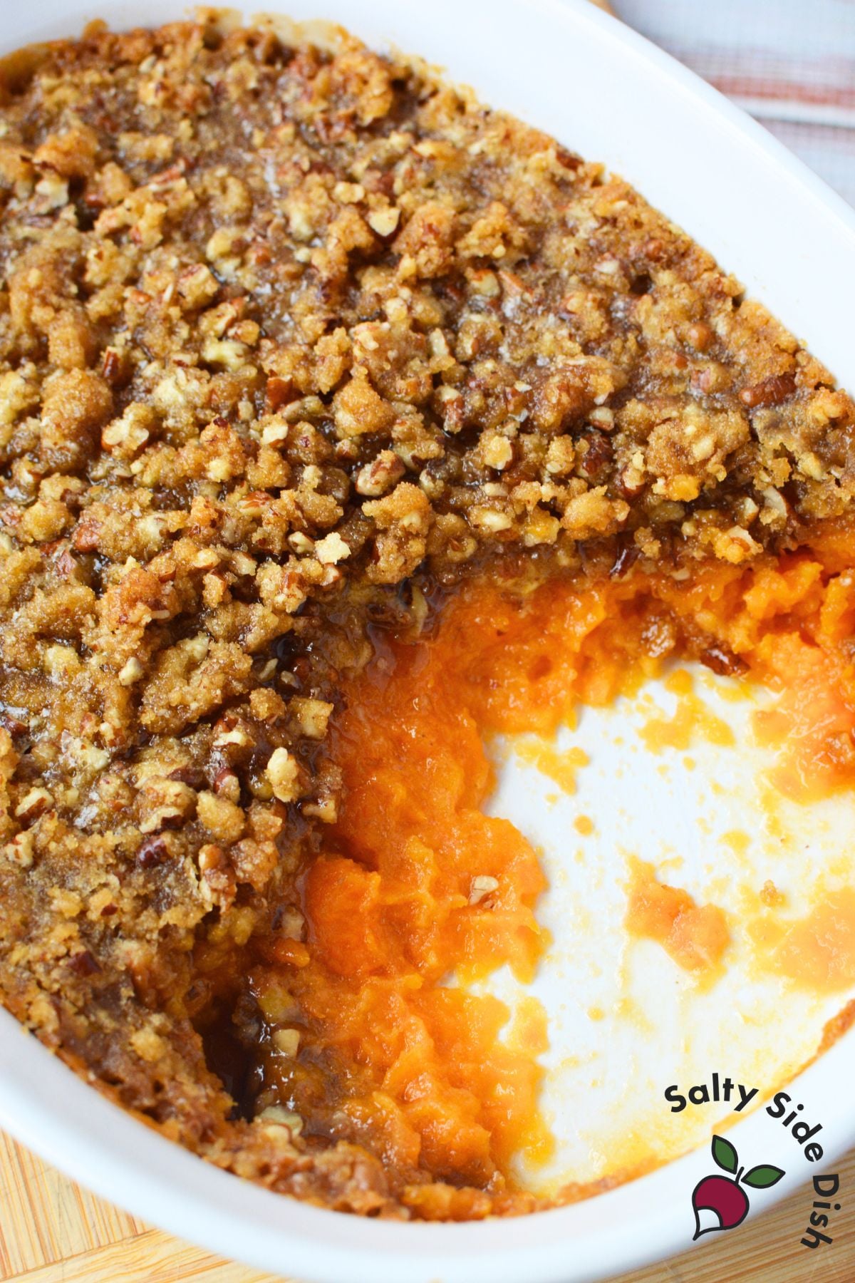 Casserole dish of sweet potato filling with baked pecan crust, easy holiday sweet potato side dish.